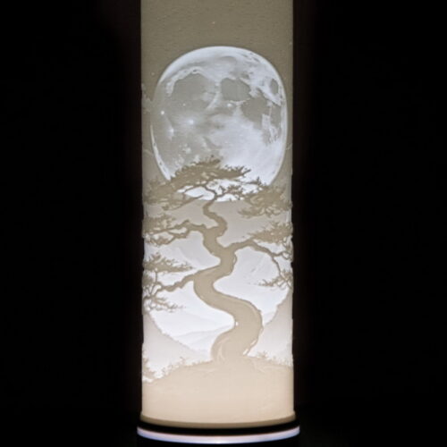Lithophanie cylindrique illuminée représentant un arbre majestueux aux formes sinueuses sous une pleine lune détaillée. Cette création en impression 3D diffuse une lumière douce et apaisante, transformant le décor en une scène poétique et Zen. Idéale comme lampe d’ambiance, décoration nocturne ou cadeau artistique, cette lithophanie combine finesse du relief, design naturel et fabrication artisanale de haute qualité. Parfaite pour sublimer un intérieur, offrir un objet unique ou créer une atmosphère relaxante dans une pièce. Mots-clés : lithophanie 3D, lampe lune, lampe arbre, décoration lumineuse, impression 3D artistique, cadeau zen, lampe d’ambiance personnalisée, lithophanie cylindrique, décoration nature, idée cadeau originale.